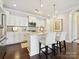 An elegant kitchen with white cabinets, an island with seating, and modern stainless steel appliances at 1226 Restoration Dr, Waxhaw, NC 28173