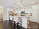 Bright, white kitchen with island seating, granite countertops, stainless appliances, and pendant lighting at 1226 Restoration Dr, Waxhaw, NC 28173