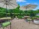 Stone patio with seating, shade umbrellas, manicured shrubbery, and a fountain at 1226 Restoration Dr, Waxhaw, NC 28173