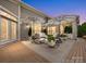 Outdoor patio area at dusk featuring elegant furniture, umbrellas, and beautiful lighting for relaxing evenings at 1226 Restoration Dr, Waxhaw, NC 28173