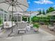 Charming patio area with elegant outdoor furniture, umbrellas, potted plants, and a cozy seating arrangement at 1226 Restoration Dr, Waxhaw, NC 28173