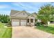Charming home featuring a stone facade, two-car garage, manicured lawn, and a welcoming front porch at 12910 Meetinghouse Dr, Cornelius, NC 28031