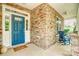 Inviting front porch features stone accents, a rocking chair, and a bright blue front door at 12910 Meetinghouse Dr, Cornelius, NC 28031