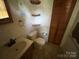 Bathroom with tiled floors, a single sink, a toilet, and wooden shelves at 1616 Lazenby St # 17, Newton, NC 28658