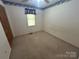 A simple bedroom with light-colored walls, carpeted floor, and a single window at 1616 Lazenby St # 17, Newton, NC 28658