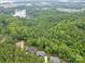 Aerial view featuring lush greenery, bodies of water and roof tops in the distance at 18238 Youngblood N Rd, Charlotte, NC 28278