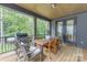 Covered porch with an outdoor dining set, grill, and wooded views, perfect for entertaining at 18238 Youngblood N Rd, Charlotte, NC 28278