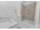 Bright white bathroom with tub-shower combination and sleek quartz vanity top at 18238 Youngblood N Rd, Charlotte, NC 28278