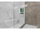 Modern bathroom with gray tiled shower and free-standing tub at 18238 Youngblood N Rd, Charlotte, NC 28278