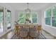 Well-lit dining area with a wood table, seating for six, and expansive windows overlooking a lush landscape at 18238 Youngblood N Rd, Charlotte, NC 28278