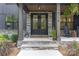 Inviting front porch with stone accents, a double door entry, and classic rocking chairs at 18238 Youngblood N Rd, Charlotte, NC 28278