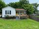 Charming home featuring a covered front porch, yellow door, well-maintained lawn, and lush landscaping at 199 Crowell Sw Dr, Concord, NC 28025