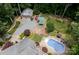Aerial view showcases a spacious backyard with a pool, garage, fire pit, and lush landscaping at 2031 Brook View Ct, Matthews, NC 28104