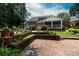 Beautiful brick patio and mature landscaping enhance this outdoor living space with a pergola and manicured lawn at 2031 Brook View Ct, Matthews, NC 28104