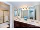 Bathroom with double sink vanity, a large mirror, decorative light fixture, and enclosed bathtub shower at 2031 Brook View Ct, Matthews, NC 28104