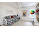 Bright bedroom with a cozy daybed, floral tapestry, rainbow window hanging, and shelving at 2031 Brook View Ct, Matthews, NC 28104