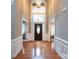 Grand foyer with soaring ceilings, hardwood floors, and transom windows over the front door at 2031 Brook View Ct, Matthews, NC 28104