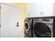 A clean, functional laundry room with modern washer and dryer and white cabinetry for storage at 2031 Brook View Ct, Matthews, NC 28104