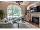 Living room showcases an oversized window, fireplace, hardwood floors and comfortable sectional sofa at 2031 Brook View Ct, Matthews, NC 28104