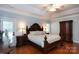 A primary bedroom features a decorative headboard, ceiling fan, and elegant lamps at 2031 Brook View Ct, Matthews, NC 28104