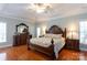 Spacious main bedroom featuring a tray ceiling, hardwood floors, and elegant furnishings at 2031 Brook View Ct, Matthews, NC 28104