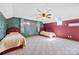 Bright bedroom with two twin beds, green accent wall, ceiling fan, and natural light from windows and skylight at 205 Harwell Rd, Mooresville, NC 28117