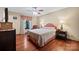 Cozy bedroom with a patterned bedspread, hardwood floors and a window with decorative curtains at 205 Harwell Rd, Mooresville, NC 28117