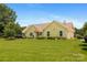 Charming yellow single-story home with a lush green lawn and well-maintained landscaping under a clear blue sky at 205 Harwell Rd, Mooresville, NC 28117