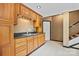 Functional kitchen with wood cabinets, modern sink, and nearby stairs at 205 Harwell Rd, Mooresville, NC 28117