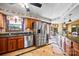 Spacious kitchen with stainless steel refrigerator, wooden cabinetry, and open access to the dining area at 205 Harwell Rd, Mooresville, NC 28117