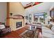 Inviting living room featuring a brick fireplace, vaulted ceiling, hardwood floors, and access to outdoor area at 205 Harwell Rd, Mooresville, NC 28117