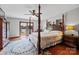 Spacious main bedroom with a four-poster bed, ceiling fan, and French doors to a balcony at 205 Harwell Rd, Mooresville, NC 28117