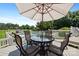 Inviting patio seating area with umbrella, overlooking the sparkling pool and lush greenery at 205 Harwell Rd, Mooresville, NC 28117