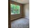 Cozy bedroom features plush carpeting and a large window overlooking lush greenery at 210 Johnson St, Troutman, NC 28116