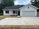 Charming single-story home boasting a white exterior, well-manicured lawn, and an attached garage at 210 Johnson St, Troutman, NC 28116