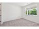 Bright bedroom features neutral carpet, white walls, large window offering natural light and exterior views at 220 Windy Dell Dr, Tega Cay, SC 29708