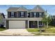 New two-story home featuring a two-car garage, neutral siding, black shutters, and manicured front lawn at 220 Windy Dell Dr, Tega Cay, SC 29708