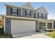 Two-story home featuring gray siding, a two-car garage, and a welcoming front porch at 220 Windy Dell Dr, Tega Cay, SC 29708