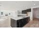 Open concept kitchen featuring black cabinets, stainless steel appliances, island and a fireplace at 220 Windy Dell Dr, Tega Cay, SC 29708