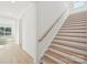 A modern staircase design with wood steps, white risers, and a wood handrail at 220 Windy Dell Dr, Tega Cay, SC 29708