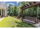 Backyard featuring a wooden swing set with a pergola, manicured lawn, and fenced border with trees at 2245 Lincolnshire Ln, Waxhaw, NC 28173