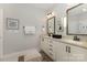 Bright bathroom featuring double vanity with granite countertops, decorative mirrors, and a neutral color scheme at 2245 Lincolnshire Ln, Waxhaw, NC 28173