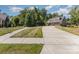 Long concrete driveway leads to a beautiful home with a well-manicured lawn and lush trees at 2245 Lincolnshire Ln, Waxhaw, NC 28173