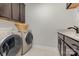 Well-equipped laundry room with modern washer and dryer, storage cabinets, and a sink at 2245 Lincolnshire Ln, Waxhaw, NC 28173