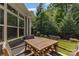 Patio area with a wooden table and four chairs, plus an artificial lawn and fenced perimeter with trees at 2245 Lincolnshire Ln, Waxhaw, NC 28173