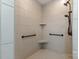 Tiled shower featuring sleek hardware, a rainfall shower head, corner shelves, and grab bars at 2245 Lincolnshire Ln, Waxhaw, NC 28173