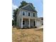 Charming two-story home featuring a welcoming front porch with white columns and an attached one-car garage at 242 North Ave, Troutman, NC 28166