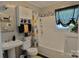 A well-lit bathroom with stylish fixtures, a shower-tub combination and storage at 252 Chuckwood Rd, Mooresville, NC 28117