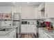Bright kitchen with white cabinetry, stainless steel appliances, and granite countertops at 2813 Ava Ave, Charlotte, NC 28208