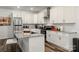 Bright kitchen features white cabinets, granite countertops, stainless steel appliances, and a stylish kitchen island with seating at 2813 Ava Ave, Charlotte, NC 28208